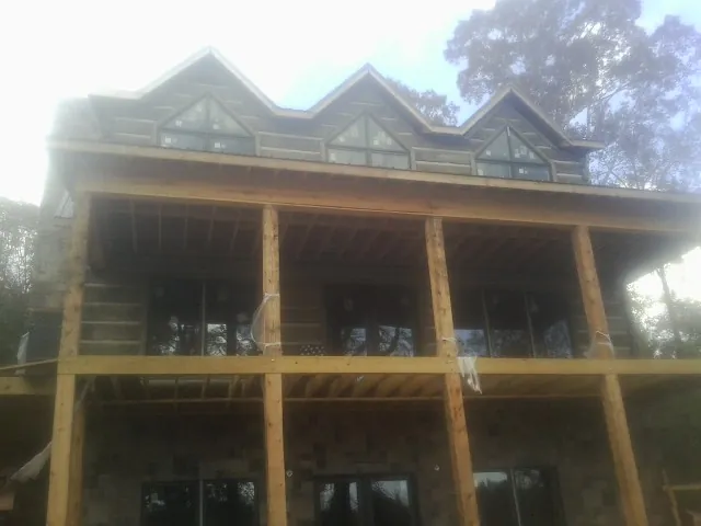 Dormers and porch framing on a large log home under construction — Roof Coating work by our crew in Bedrock