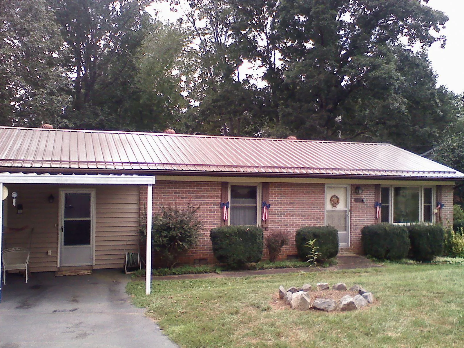 Bronze metal roof and carport on a brick ranch home — Roof Repair work by our crew in Bedrock